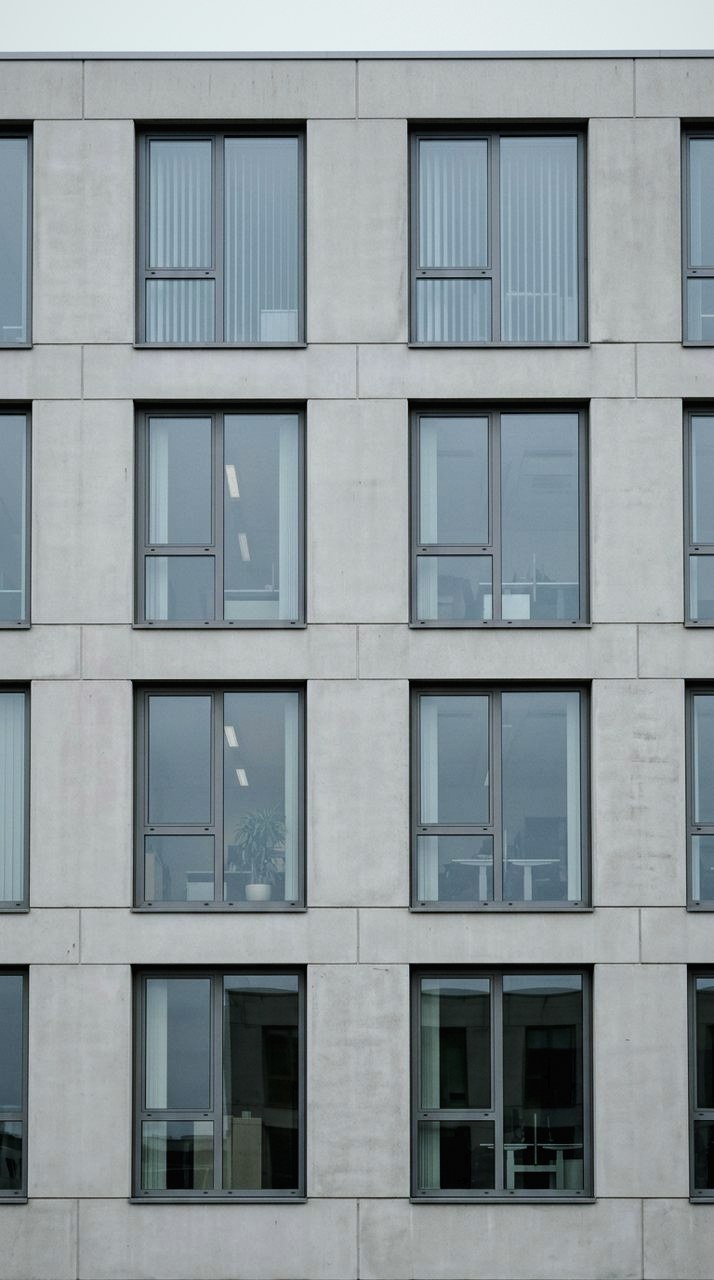 Graded with Buildings and Rooms: Elevation, board-formed: heavy texture, cool neutral grey, the mass read.